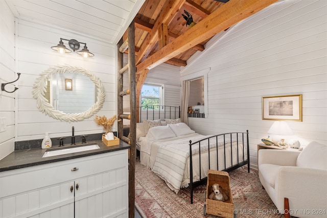 bedroom featuring wooden ceiling, wooden walls, lofted ceiling with beams, and sink