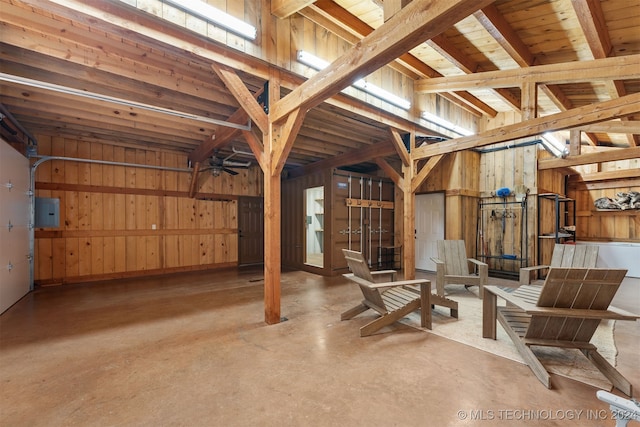 basement with electric panel, wood walls, and a wealth of natural light