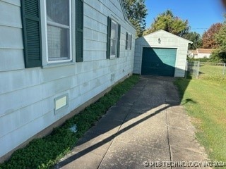 view of property exterior featuring a yard, an outdoor structure, and a garage