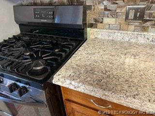 interior details with gas stove and light stone counters