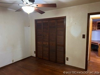 unfurnished bedroom with ceiling fan, a closet, and dark hardwood / wood-style flooring