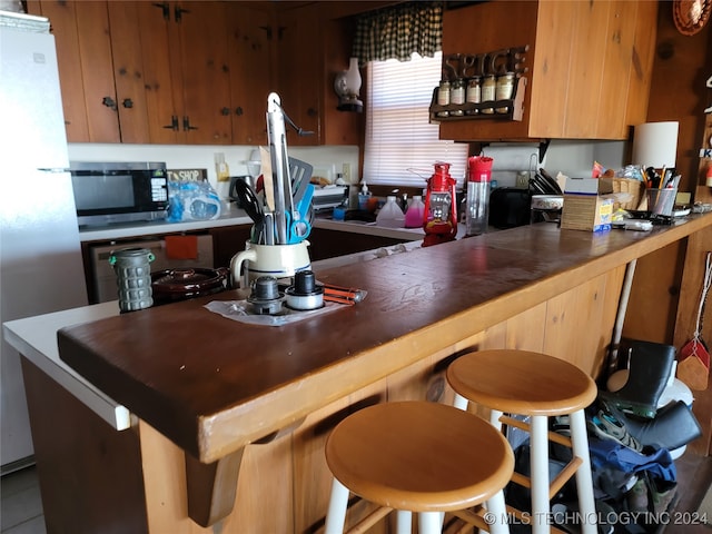 kitchen featuring a kitchen bar and appliances with stainless steel finishes