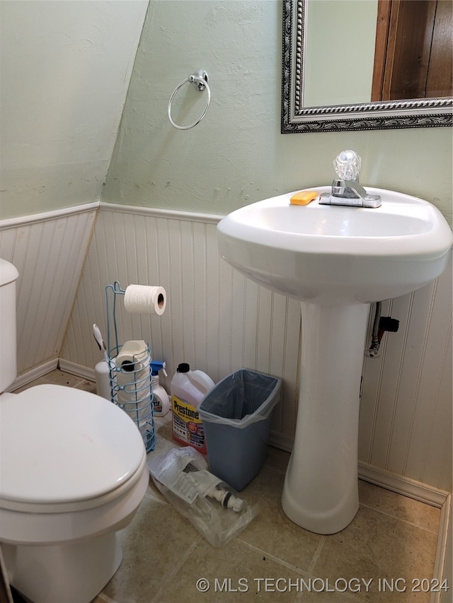 bathroom featuring wooden walls, toilet, and tile patterned floors