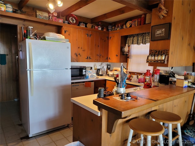 kitchen with a kitchen breakfast bar, white appliances, light tile patterned flooring, and kitchen peninsula