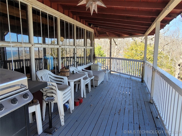 deck featuring area for grilling and ceiling fan