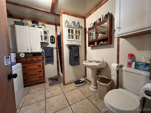 bathroom featuring toilet, washer / dryer, and tile patterned floors