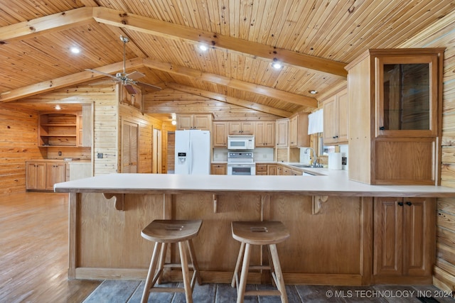 kitchen with wood walls, lofted ceiling with beams, light wood-type flooring, white appliances, and kitchen peninsula