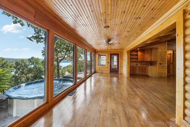 unfurnished sunroom with ceiling fan and wooden ceiling