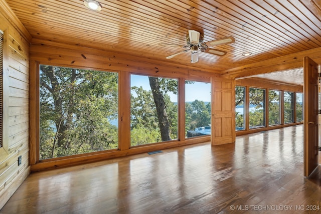 unfurnished sunroom with wood ceiling, a wealth of natural light, and ceiling fan