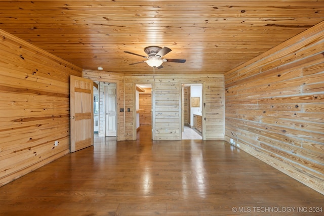 unfurnished room with wooden walls, wood ceiling, and hardwood / wood-style floors