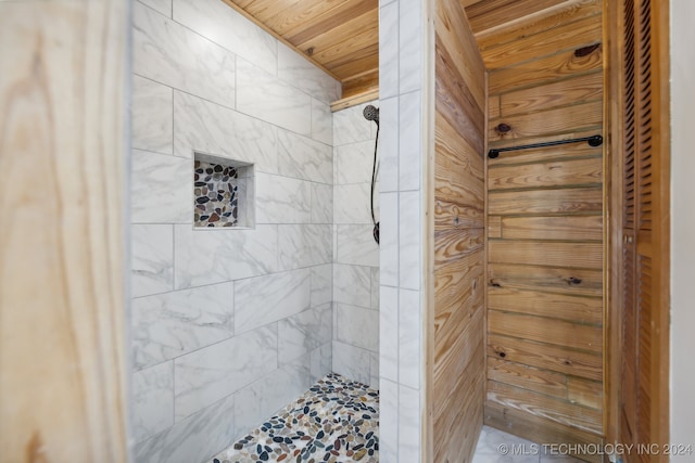 bathroom with a tile shower and wood ceiling