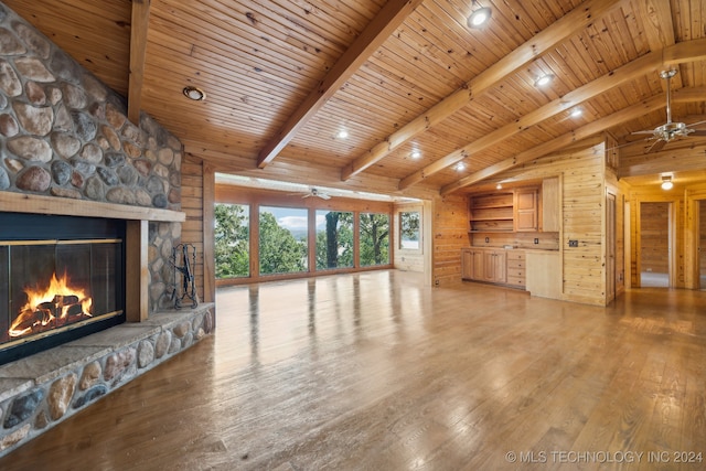 unfurnished living room featuring vaulted ceiling with beams, light wood-type flooring, a fireplace, and wooden ceiling