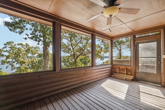 unfurnished sunroom featuring ceiling fan and a wealth of natural light