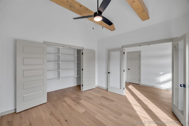 unfurnished bedroom featuring ceiling fan, beamed ceiling, high vaulted ceiling, a closet, and light hardwood / wood-style floors