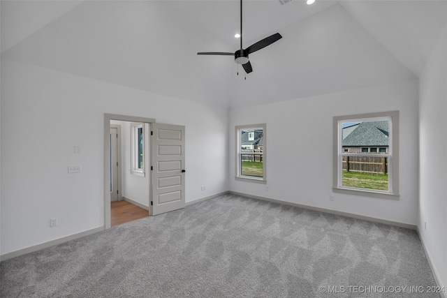 unfurnished bedroom with ceiling fan, light colored carpet, and high vaulted ceiling