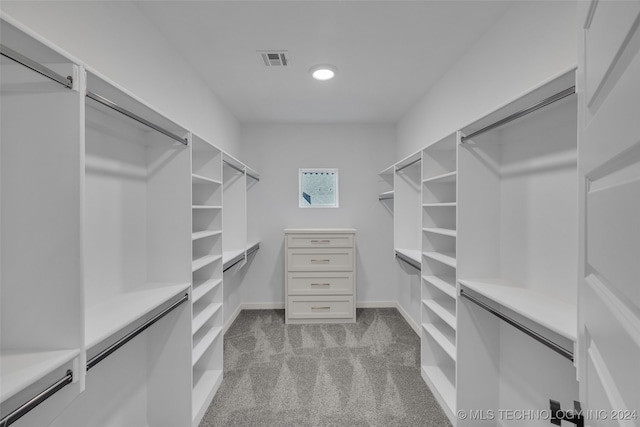 walk in closet featuring light carpet