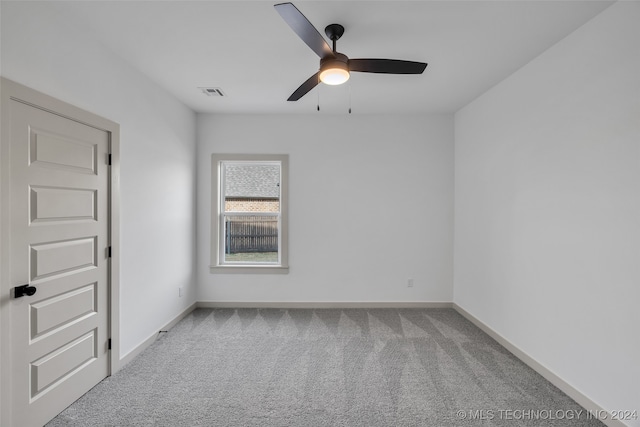 empty room featuring ceiling fan and light carpet