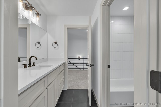 bathroom featuring tile patterned flooring, a tub to relax in, and vanity