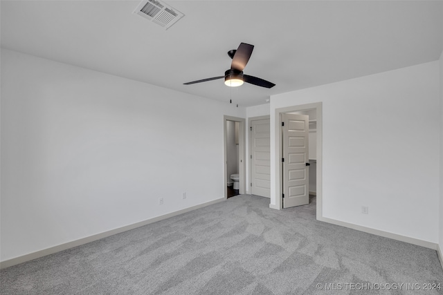 unfurnished bedroom with connected bathroom, ceiling fan, and light colored carpet