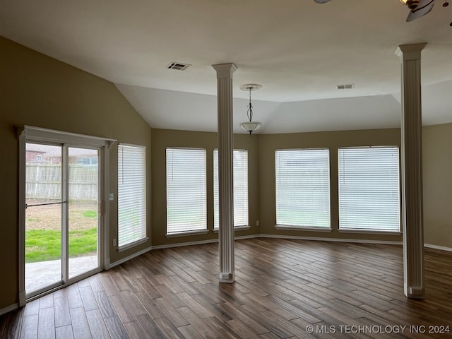 empty room with vaulted ceiling, dark hardwood / wood-style floors, and ornate columns