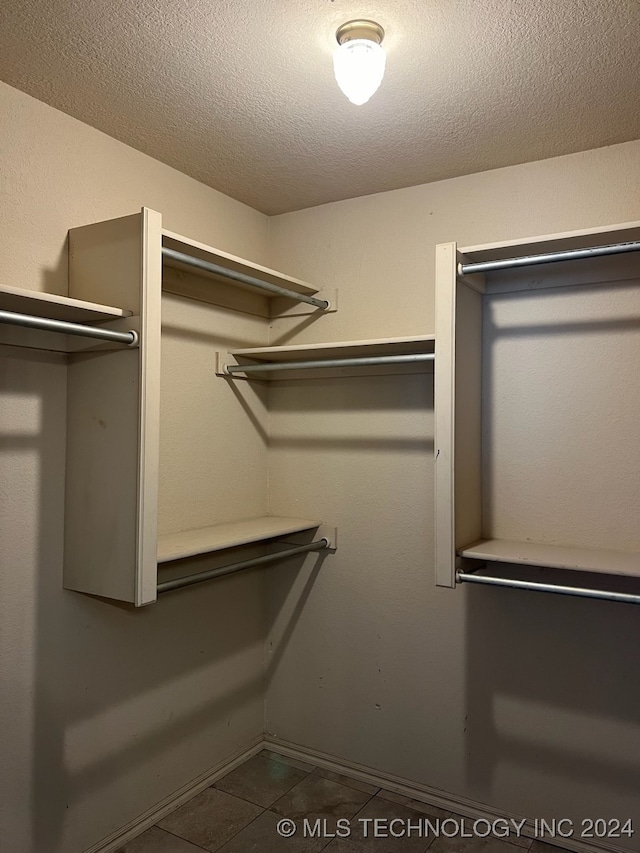 walk in closet featuring dark tile patterned flooring