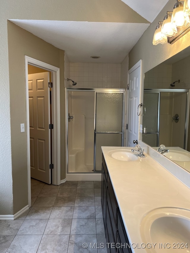 bathroom with vanity, tile patterned floors, and a shower with door