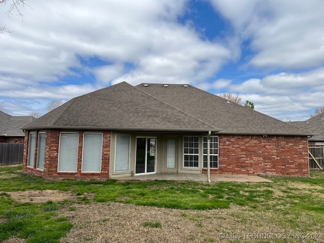 rear view of house with a yard and a patio