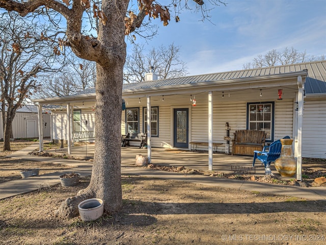 view of front of home featuring a storage shed and a porch