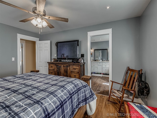 bedroom with ceiling fan, ensuite bath, and wood-type flooring