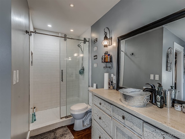 bathroom featuring vanity, hardwood / wood-style floors, toilet, and a shower with door