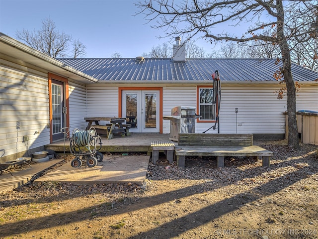 rear view of property with a wooden deck and french doors