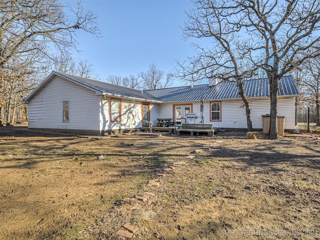 back of property with a deck and a yard