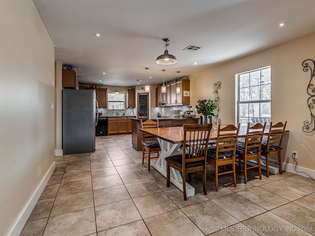 dining space featuring light tile patterned flooring and a healthy amount of sunlight