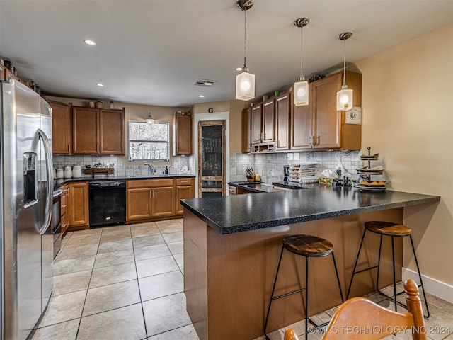 kitchen with kitchen peninsula, dishwasher, stainless steel fridge with ice dispenser, and a breakfast bar