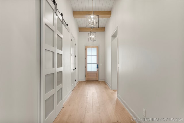 doorway with a barn door, light wood-type flooring, wooden ceiling, beam ceiling, and an inviting chandelier