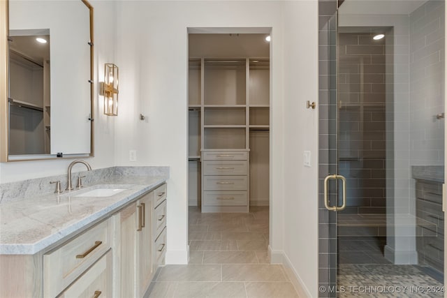 bathroom with vanity, a shower with shower door, and tile patterned flooring