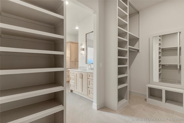 spacious closet with light tile patterned flooring and sink