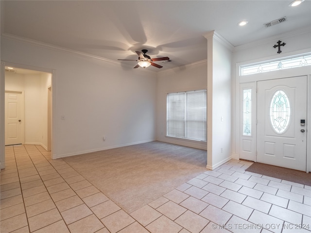 carpeted foyer entrance with crown molding and ceiling fan