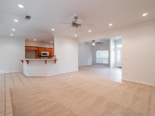 unfurnished living room with ceiling fan, light tile patterned flooring, and ornamental molding