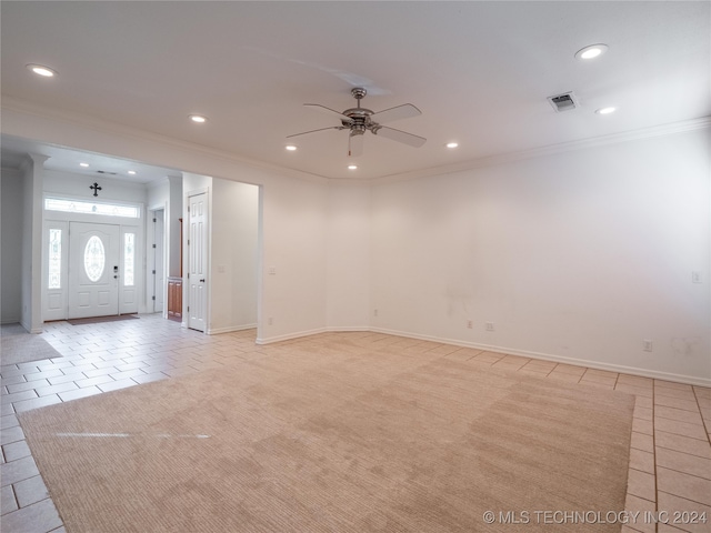 interior space with ornamental molding, ceiling fan, and light carpet