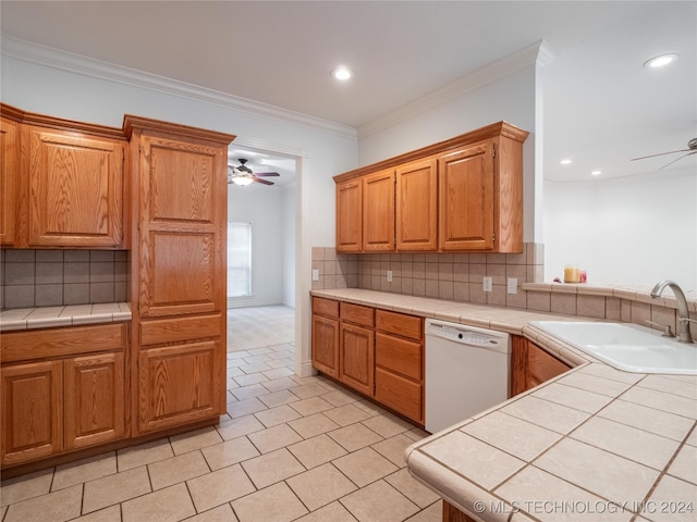 kitchen featuring white dishwasher, tile countertops, ceiling fan, ornamental molding, and sink