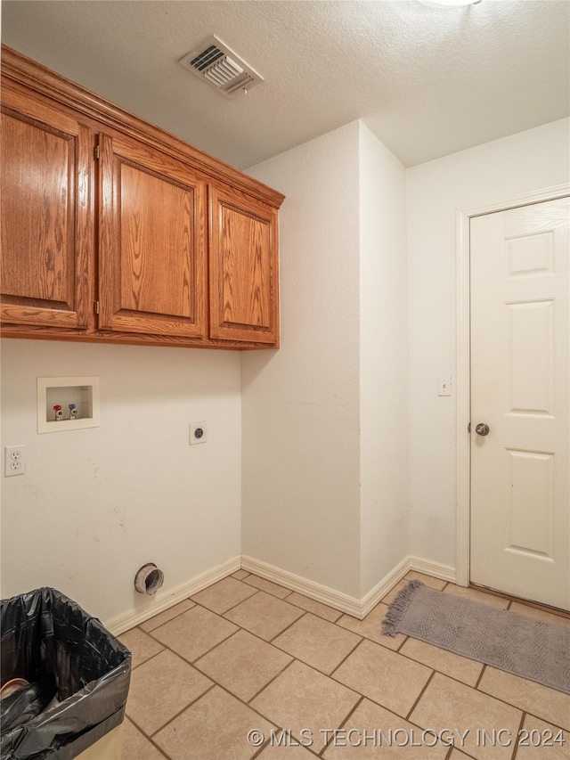 laundry room featuring washer hookup, light tile patterned floors, a textured ceiling, cabinets, and electric dryer hookup