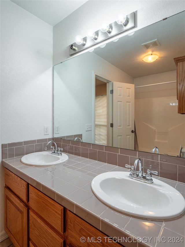 bathroom featuring vanity and tasteful backsplash