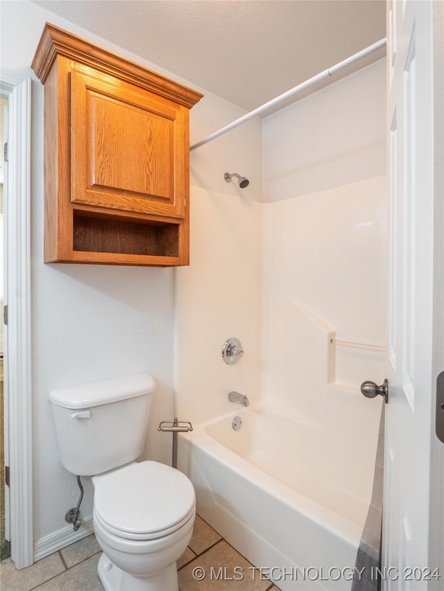 bathroom with shower / tub combination, tile patterned flooring, and toilet