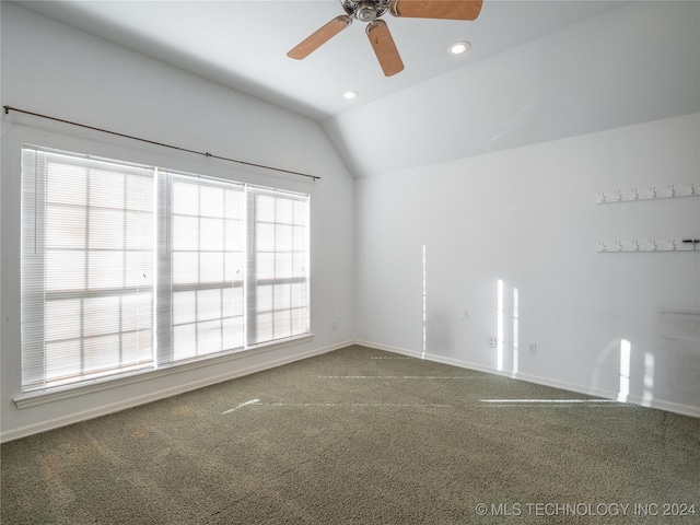 carpeted empty room featuring ceiling fan, lofted ceiling, and a healthy amount of sunlight