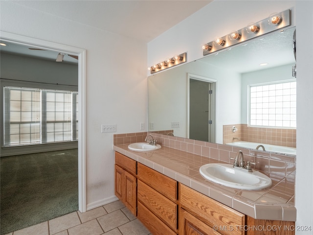 bathroom with a bathtub, vanity, and tile patterned floors