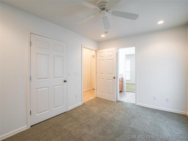 unfurnished bedroom with light carpet, a closet, ensuite bath, and ceiling fan