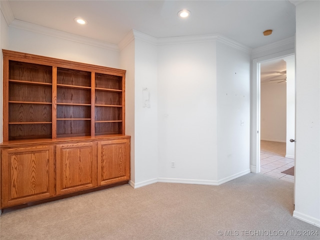 unfurnished living room featuring ornamental molding, ceiling fan, and light carpet