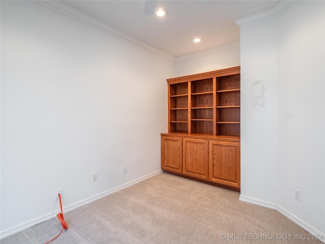 spare room featuring light carpet and crown molding