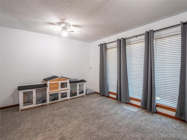 carpeted empty room featuring a textured ceiling and ceiling fan